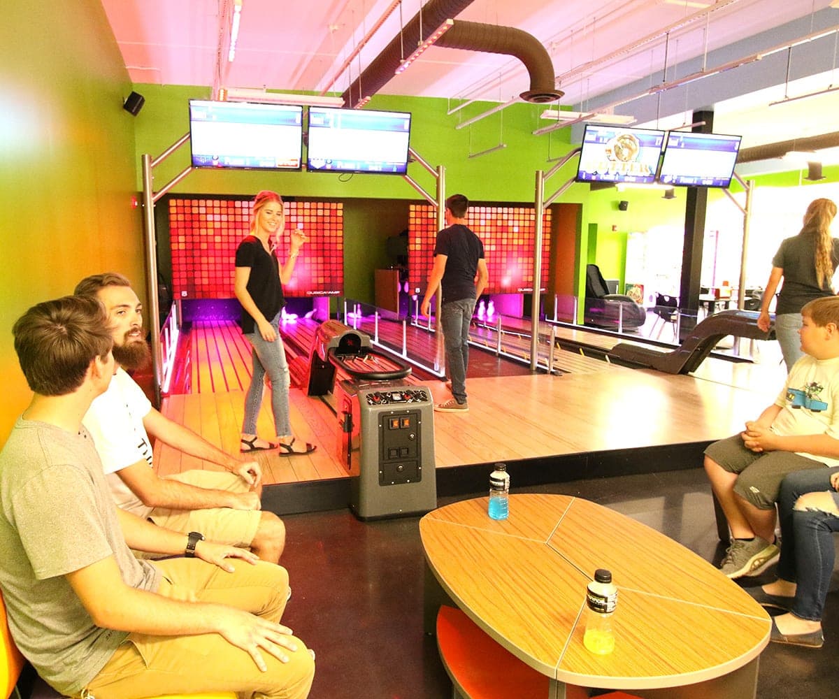 friends chat with bowling alleys in the background