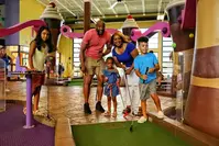 family playing indoor mini golf in Pigeon Forge at Crave Golf Club