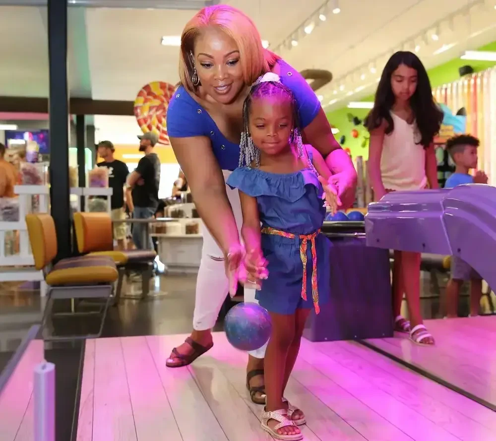 mother helping young daughter play Mini Bowling at Crave Golf Club in Pigeon Forge TN